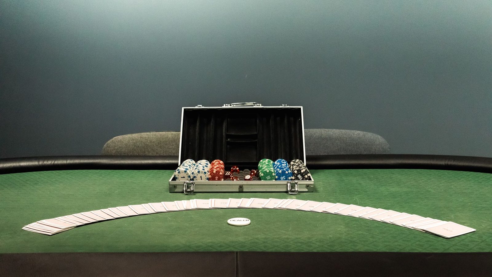 Close-up of poker hand holding four aces and kings with colorful chips on green table for high-stakes gaming.