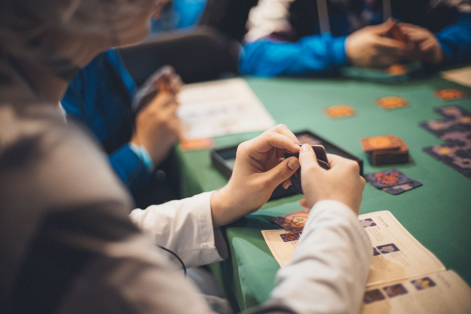 Close-up of poker hand holding four aces and kings with colorful chips on green table for high-stakes gaming.